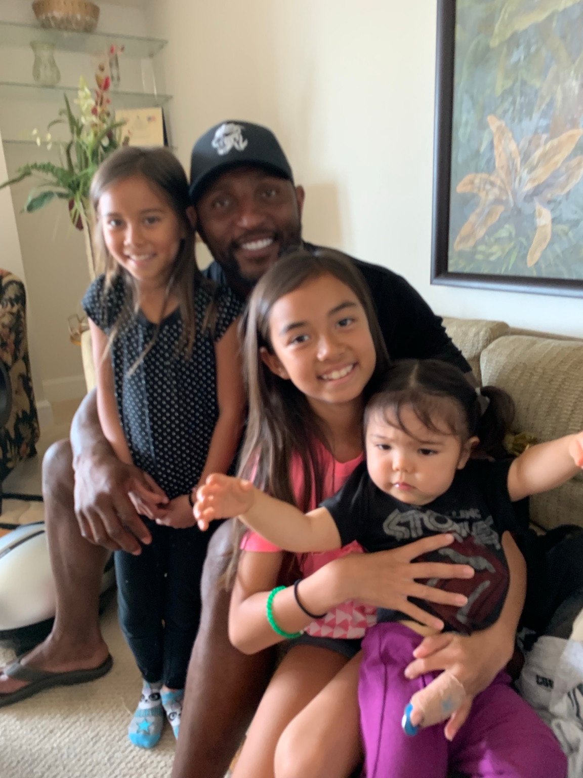 A childhood photo of Kaylia with family, sitting with former NFL linebacker Ray Lewis